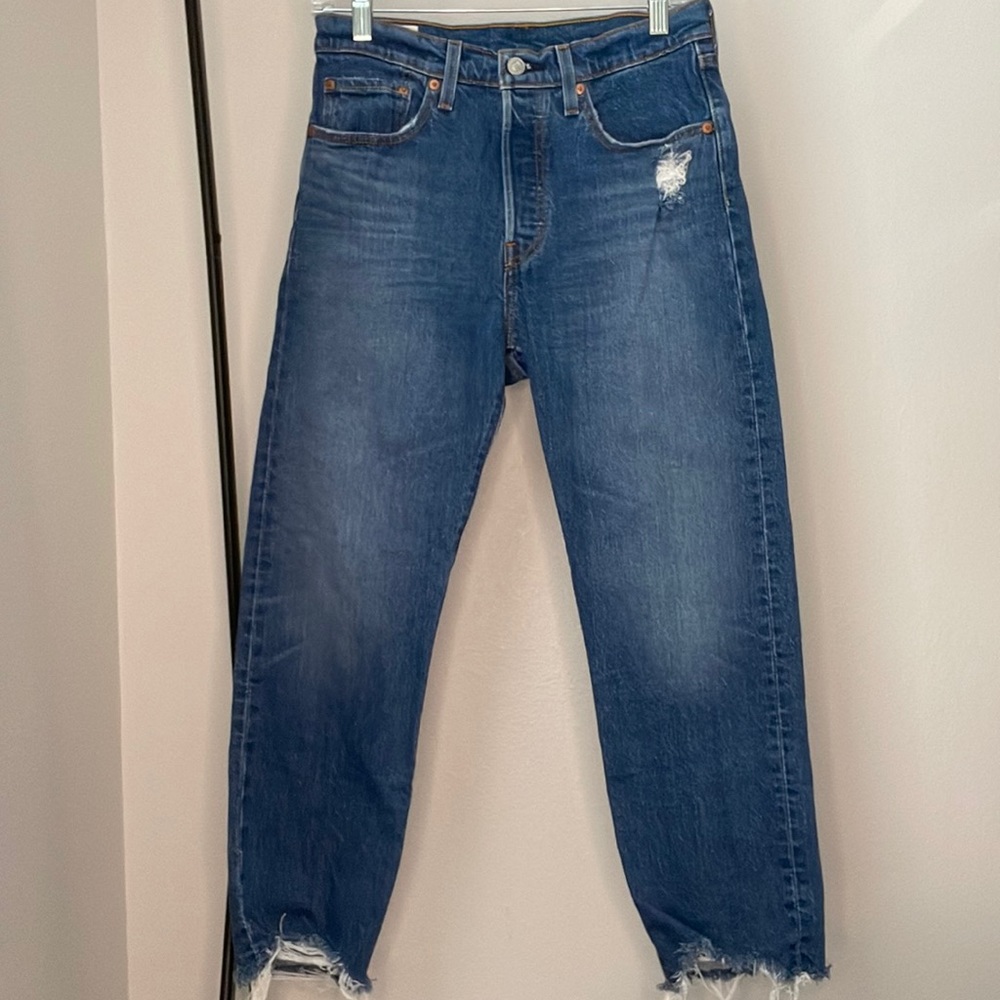 Medium wash distressed Levi’s 501 original jeans